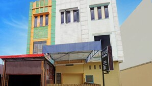 A multi-story building with a sign for 'Hotel' and 'Ministry Residence.' - Cozy Double Escape W/ Free WiFi and Parking (Medan)