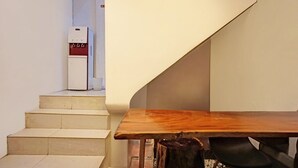 A staircase leading to a room with a wooden table and a white appliance, possibly a refrigerator, in the background. - Cozy Double Escape W/ Free WiFi and Parking (Medan)