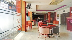 A modern hotel lobby with a staircase, a bar area, and seating arrangements.
