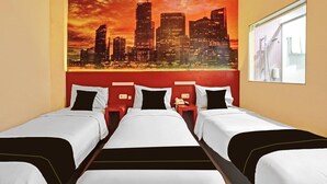 Ein Hotelzimmer mit drei Betten, einem Stadtbild-Wandgemälde, einem Fenster mit Blick und einem roten Kopfteil.