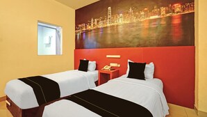 Ein Hotelzimmer mit zwei Betten, einem Stadtbild, einem Fenster und einem Telefon auf einem Nachttisch.