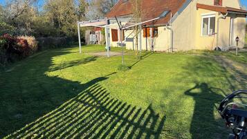 Une maison avec un toit en pente, un patio couvert et une pelouse bien entretenue.
