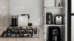 A modern kitchen with a gas stove, a coffee maker, a toaster, and a built-in oven. - Stylish 2BR + Sofa Bed Apartment | Prospect (Prospect)