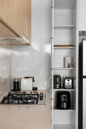 Eine moderne Küche mit Gasherd, Kaffeemaschine, Toaster und Backofen.