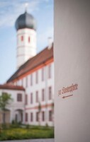 A building with a dome and the text 'zur Rosteforde' on a white background.