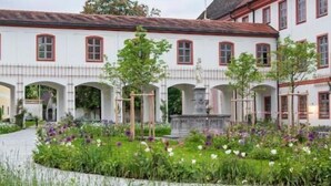 A historic building with a tower, arched walkways, and a garden. - Kloster Beuerberg  (Beuerberg)