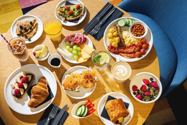 Een ontbijttafel met diverse etenswaren en drankjes.
