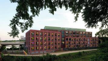 A multi-story building with a brick facade, large windows, and a flat roof.