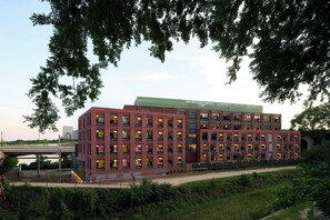 Un edificio de varios pisos con fachada de ladrillo, ventanas amplias y techo plano.