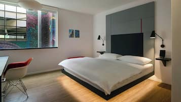 A modern bedroom with a bed, a desk, and a chair.