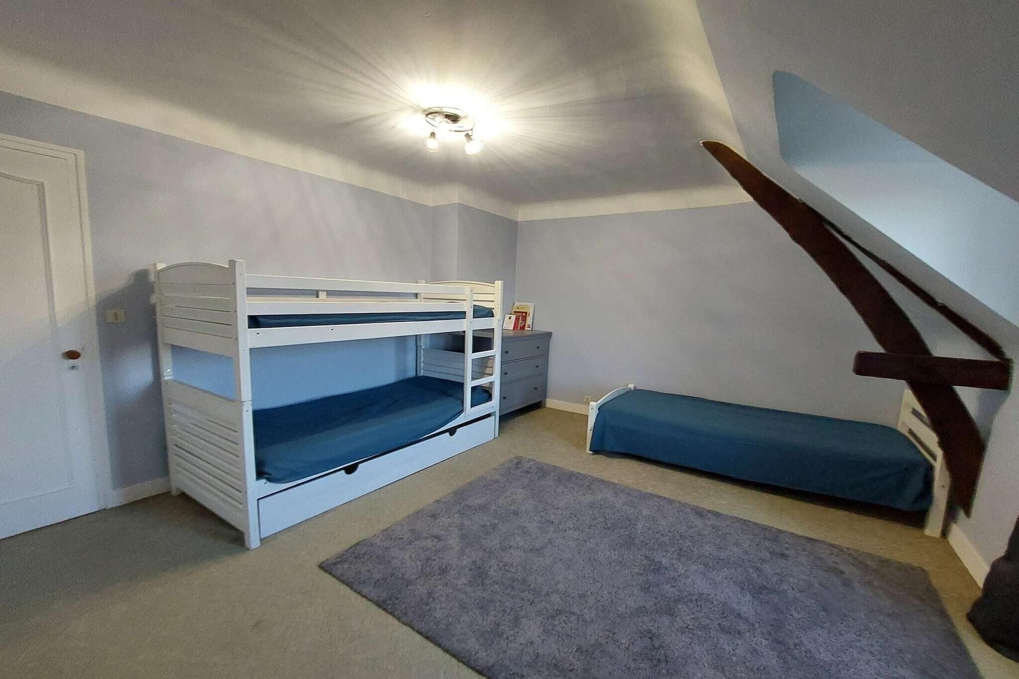 Una habitación con literas, un escritorio y una silla.