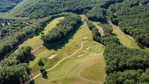 An aerial view of a golf course with multiple fairways, sand traps, and a water hazard. - Cottage in Lachapelle-Auzac with Pool (LACHAPELLE AUZAC)