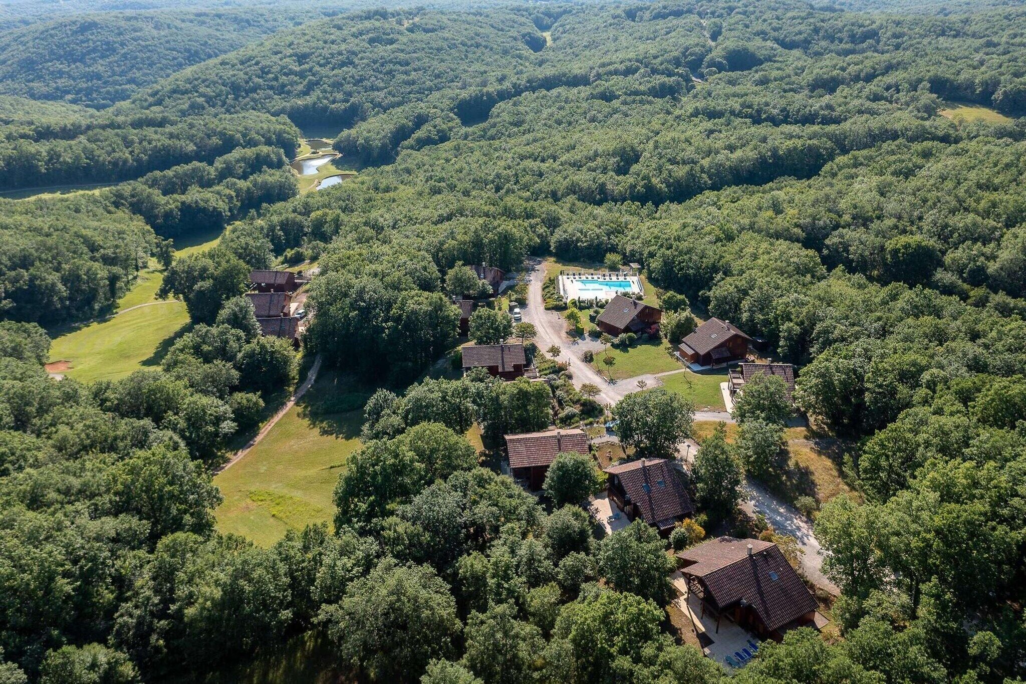 Vista aérea de una zona residencial con varias casas, una piscina y un río.