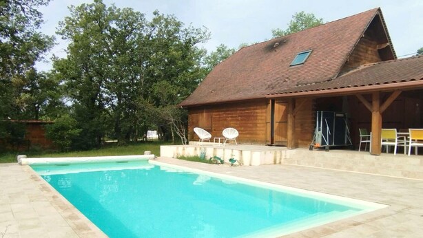 A wooden cabin with a swimming pool, outdoor seating, and a covered patio area. - Home with Enclosed Garden near Sarlat (PECHS DE L'ESPERANCE)