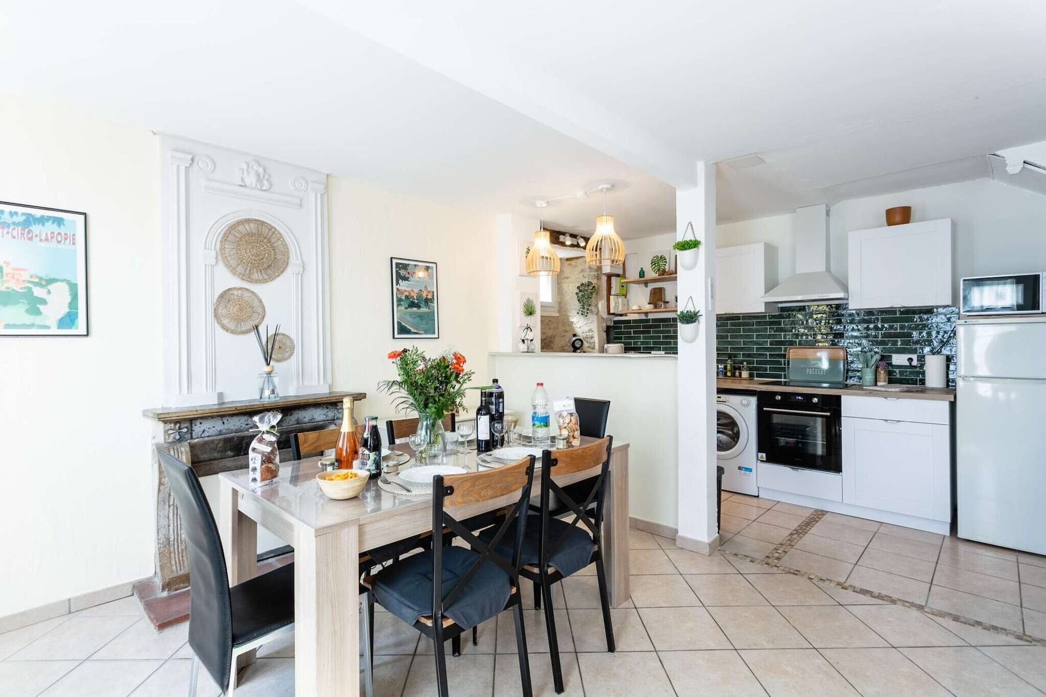 A modern kitchen with white cabinets, a dining table with chairs, and a built-in oven.