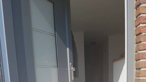 A dog lying on a wooden floor near a door with a glass panel. - Vacation apartment Geestland "buten un binnen" North Sea (Geestland)