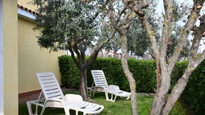Outdoor lounge chairs near a building with a tiled roof, surrounded by greenery. - P086 - Porto Recanati, villa with garden and terrace (Porto Recanati)