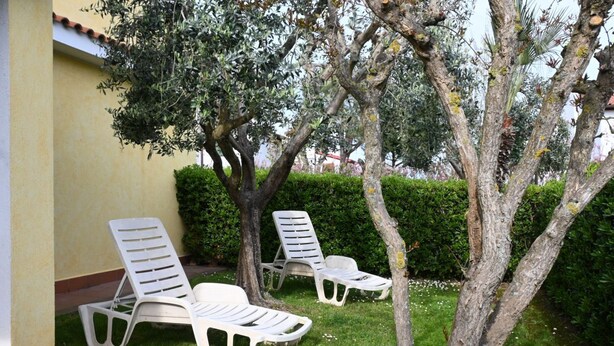 Outdoor lounge chairs near a building with a tiled roof, surrounded by greenery. - P086 - Porto Recanati, villa with garden and terrace (Porto Recanati)