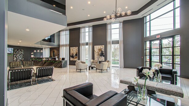 A spacious lobby with a high ceiling, large windows, and modern furnishings. - Home Movie Theatre. Walk to FIFA/NRG/Med Center. 1BDR Highrise (Houston)