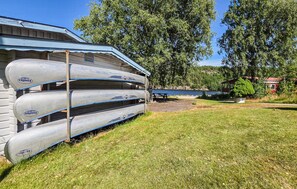 A building with a covered outdoor area, a picnic table, and a row of canoes. - Cozy home in Göta with WiFi (Göta)