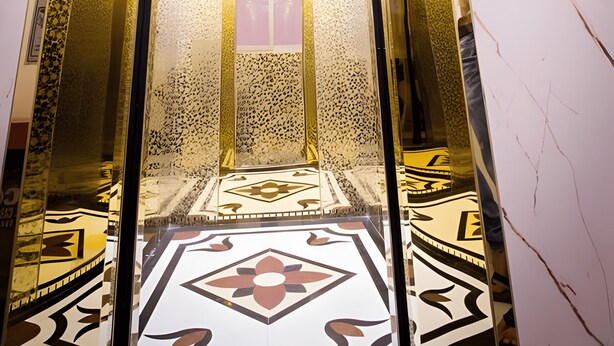 Un ascensor con interior reflectante y baldosas de suelo estampadas.