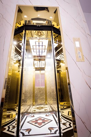 An elevator with a reflective interior and patterned floor tiles. - 1991 Hotel Phan Thiet (Phu Thuy)