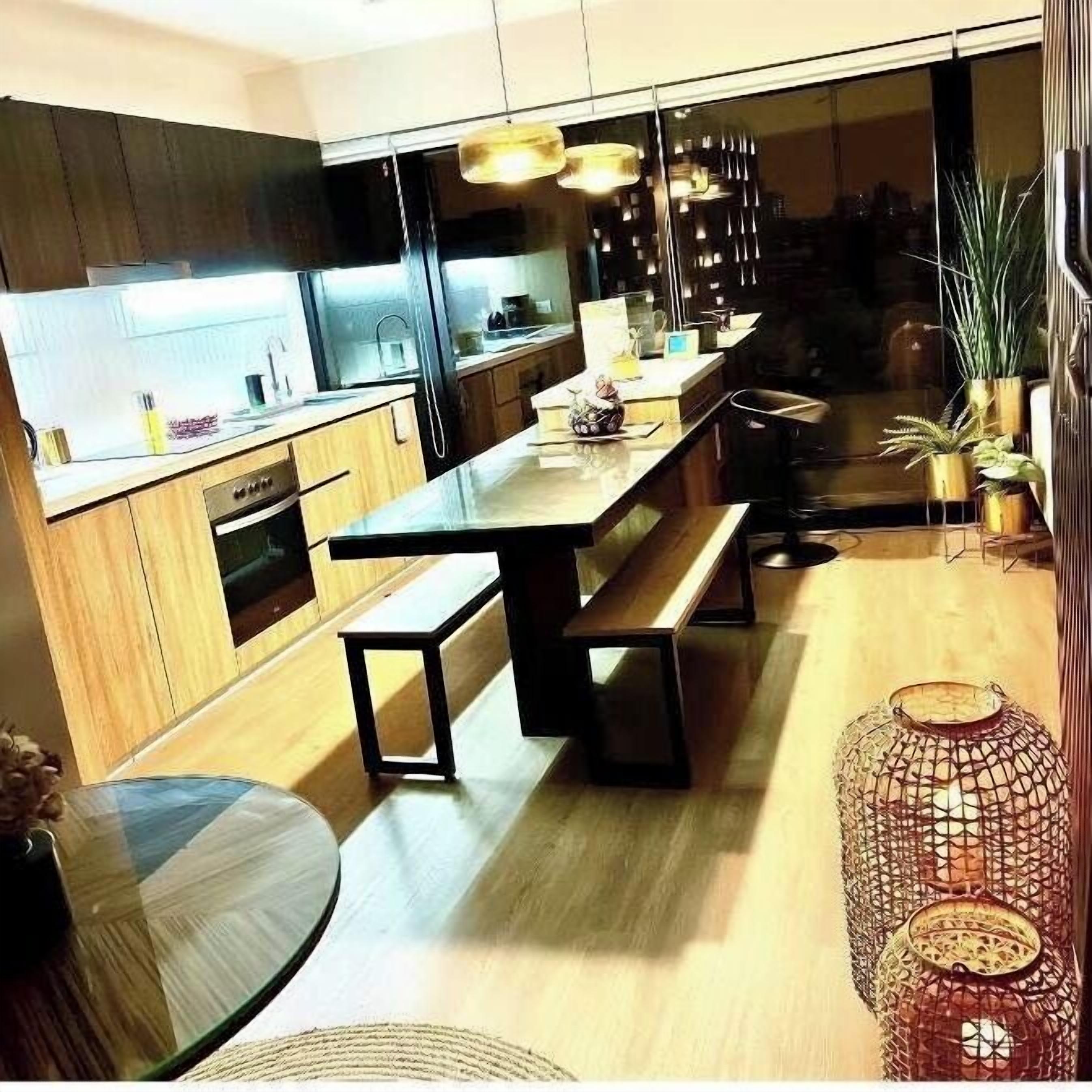 Een moderne keuken met houten kastjes, een centraal eiland en hanglampen.