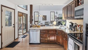 Una cucina moderna con mobili in legno, forno integrato e un'isola ampia con lavello.