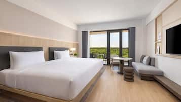 A hotel room with a large bed, a sofa, a small table, and a TV.