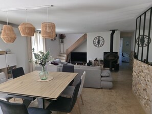 A modern living room with a dining table, sofas, a TV, and a fireplace. - Villa with swimming pool, not overlooked, in quiet town center - sea 15 minutes away (Marignane)