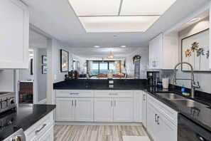 Open platform kitchen - Enjoy this 20th floor 2BR/2BA penthouse condo in Daytona Shores with stunning ocean views from the living area, master bedroom, and balcony. Sherwin amenities include a heated pool, fitness center, sauna, hot tub, and indoor garage parking. (Daytona Shores)