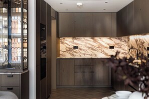 A modern kitchen with marble backsplash, wooden cabinets, and a built-in oven. - 3 Mins Walk to Westminster Abbey, Luxury Retreat (Greater London)