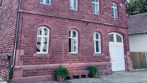 Un edificio de ladrillo rojo con varias ventanas y una puerta blanca.
