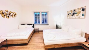 Una habitación con dos camas, una ventana y un radiador.