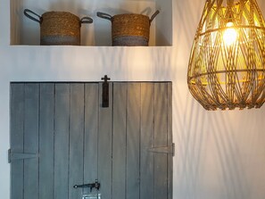 A rustic wooden door with a metal latch, a woven basket hanging above it, and a woven light fixture. - Charming Garden Holiday Home for 6 (Durbuy)