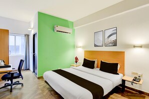 A hotel room with a bed, bedside table, lamp, and an air conditioning unit. - Super Townhouse SR Nagar Metro Hyderabad (Hyderabad)