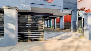 A covered parking area with metal gates and a paved walkway. - Super Townhouse SR Nagar Metro Hyderabad (Hyderabad)