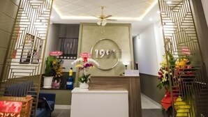A reception area with a modern ceiling light fixture, a reception desk, and decorative elements. - 1991 Boutique Hotel Phan Thiet (Phu Thuy)
