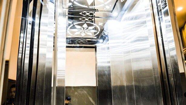 An elevator with a metallic interior and reflective surfaces. - 1991 Boutique Hotel Phan Thiet (Phu Thuy)