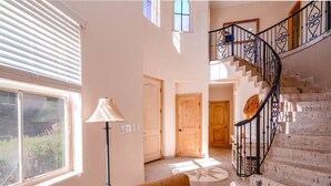 Eine Treppe mit schwarzer Geländer, Holztüren und einer Stehlampe.