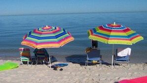 Una playa con sombrillas a rayas y sillas de playa.