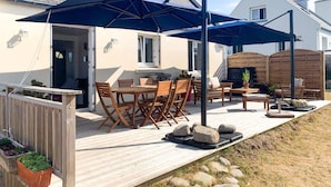 A patio with outdoor furniture, a wooden deck, and a large umbrella. - Plouguerneau Coastal Retreat With Garden (Lampaul-Plouarzel)