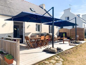 A patio with outdoor furniture, a wooden deck, and a large umbrella. - Plouguerneau Coastal Retreat With Garden (Lampaul-Plouarzel)