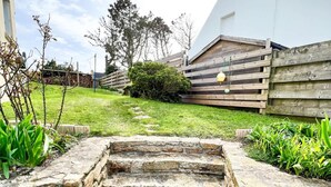A stone staircase leading up to a wooden deck with a grassy area and a wooden fence. - Plouguerneau Coastal Retreat With Garden (Lampaul-Plouarzel)