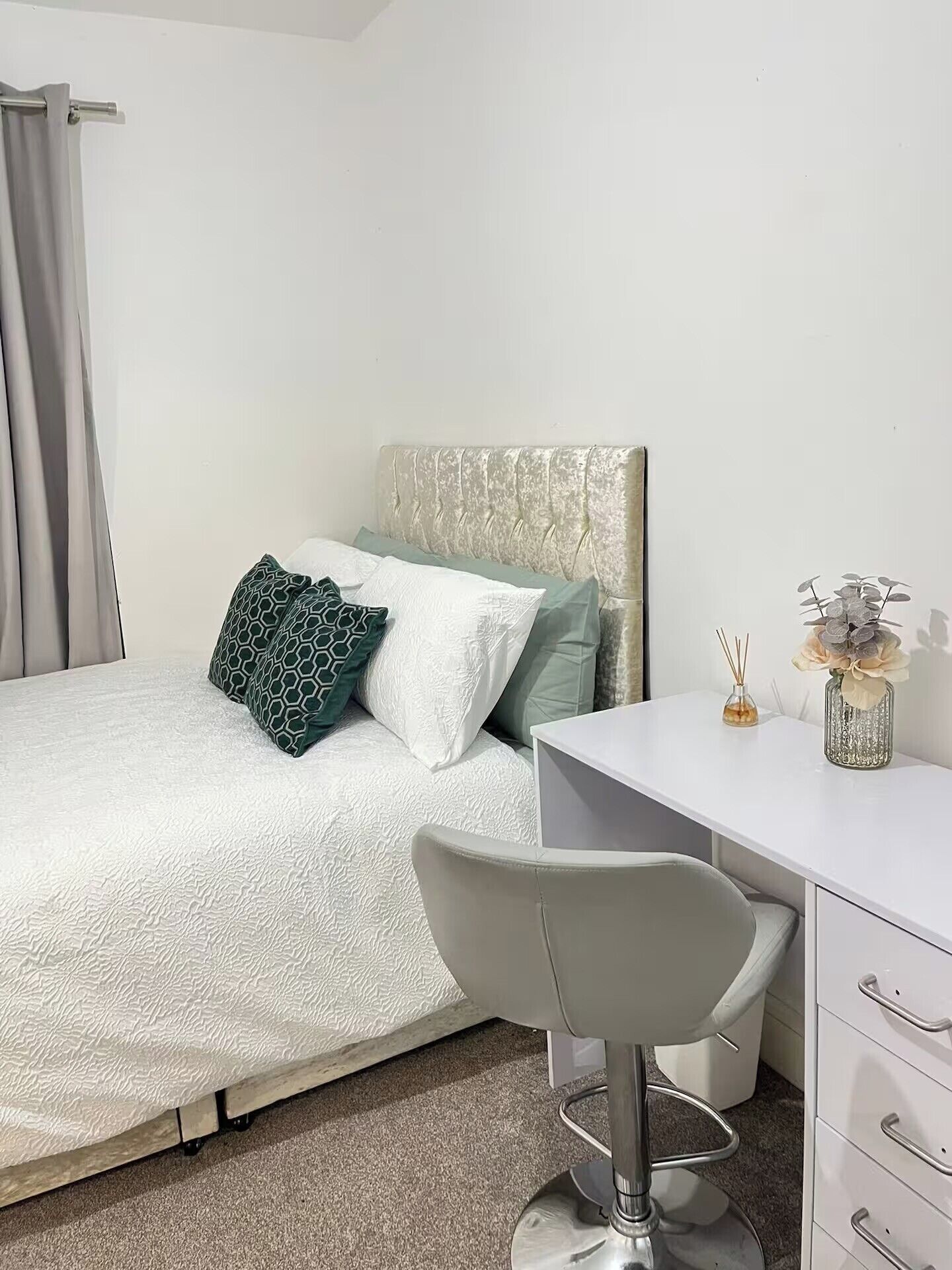 Een moderne slaapkamer met een bed, een bureau en een stoel.