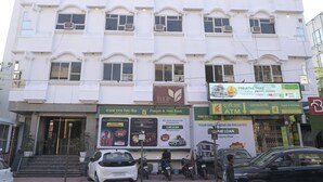 A multi-story building with commercial establishments on the ground floor, including an ATM and a bank. - The Tulip Regency (Jaipur)