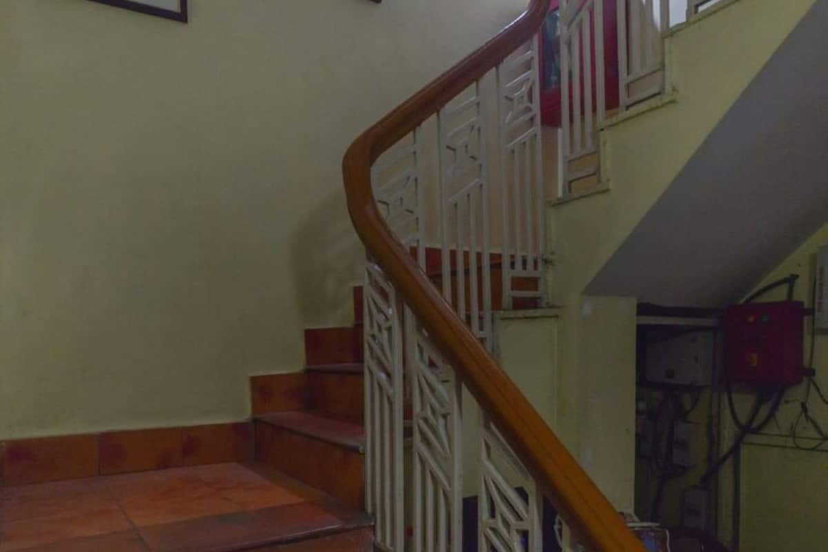 Una escalera con barandillas de madera y pasamanos blancos que conduce a un piso superior.