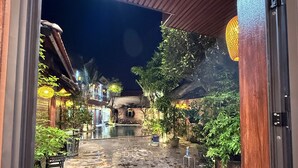 An outdoor courtyard with stone flooring, potted plants, and a soccer ball. - Tam Coc Green Vibes Retreat (Nam Hoa Lu)
