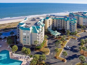 A beachfront hotel with multiple buildings, a parking lot, and a swimming pool. - Cambridge 410 - Beautiful Condo in Litchfield by the Sea (Pawleys Island)