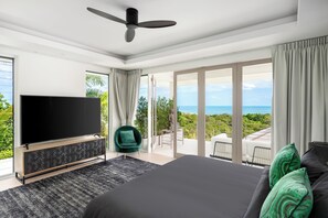 Ein modernes Schlafzimmer mit einem großen Bett, einem Fernseher und einem Balkon mit Blick.